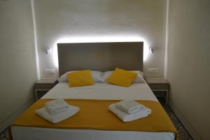 a bedroom with a bed with two towels on it at Sa Domo e tzia Caterina in Orgosolo