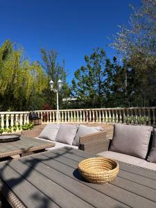 a wooden table with a couch on a deck at Carrasca 8 paddle & pool in Alcoy