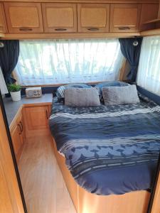 a bed in the back of an rv at Camping de Zandhorst, Toercaravan Fendt in Wouterswoude
