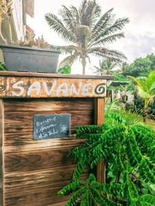 a sign for a garden with a palm tree in the background at Sur L'Anse in Terre-de-Haut