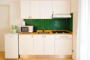 a kitchen with white cabinets and a microwave at Océan serinity Santa Maria in Santa Maria