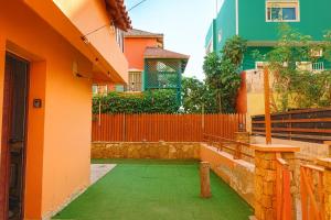 an orange building with a green floor and a fence at Océan serinity Santa Maria in Santa Maria +7 photos