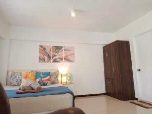 a bedroom with a bed with a stuffed animal on it at Affordable Travellers Studio Condo near Mactan Airport by A&C in Pusok