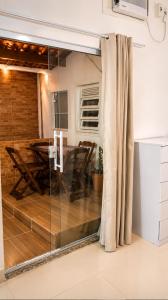 a room with a glass partition with a table and chairs at Apartamento em Condomínio - Centro de Búzios in Búzios