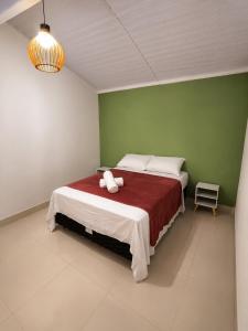 a bedroom with a bed with a red and white blanket at Apartamento em Condomínio - Centro de Búzios in Búzios