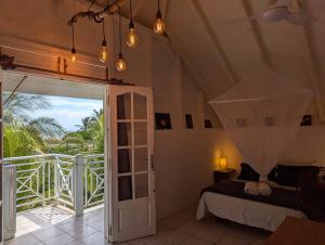 a bedroom with a bed and a door to a balcony at Sur L'Anse in Terre-de-Haut +11 photos
