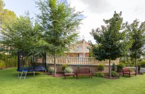 a yard with a playground with benches and trees at Carrasca 8 paddle & pool in Alcoy