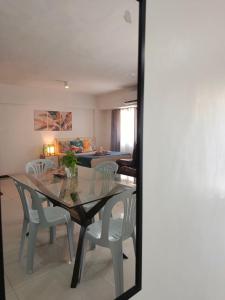 a dining room with a glass table and chairs at Affordable Travellers Studio Condo near Mactan Airport by A&C in Pusok +25 photos