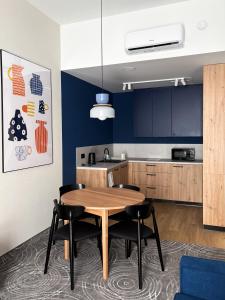 a kitchen with a wooden table and black chairs at Cobalt36 in Bolesławiec