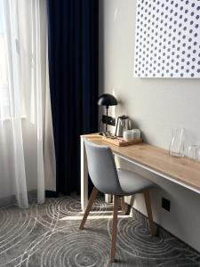 a desk with a chair in a room with blue curtains at Cobalt36 in Bolesławiec