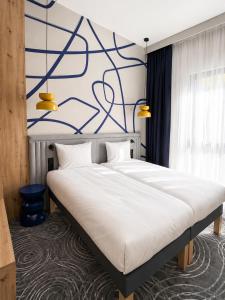 a bedroom with a bed with a blue and white wall at Cobalt36 in Bolesławiec
