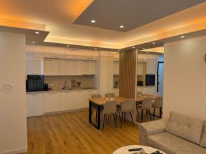 a living room and kitchen with a table and a couch at Sarajevo Waves Aparthotel in Sarajevo