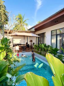 a group of children playing in a swimming pool in a house at Samphia Homestay in Nguyệt Hòa