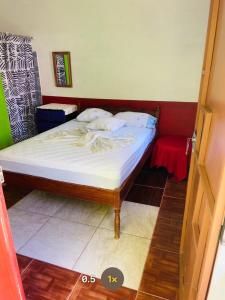 a small bedroom with a bed with white sheets at Beach cabin ometepe in Altagracia