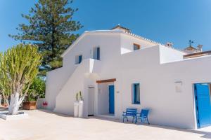 a white house with two blue chairs in front of it at Boho Suites Denia in Denia