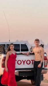 a man and a woman standing in front of a truck at Luxury cMp in Al Karāmah