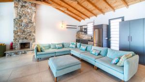 a living room with a blue couch and a fireplace at Villa Lagerta in Kayakoy