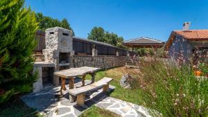a garden with two benches and a stone fireplace at Villa Lagerta in Kayakoy