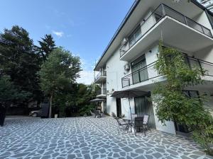 a building with chairs and an umbrella on a patio at Borjomi Central in Borjomi