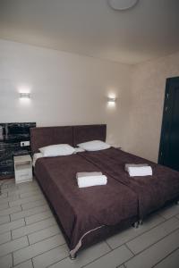 a bedroom with a large bed with two towels on it at NACHIKU Bukovel Resort & SPA in Palyanytsya +86 photos