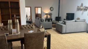 a living room with couches and a table and chairs at Nirvana camp in Matola