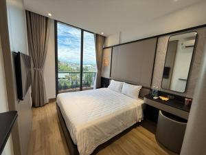 a hotel room with a bed and a large window at Palm Hotel in Tam Kỳ +22 photos