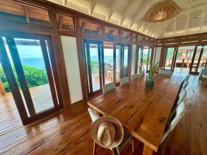 a dining room with a large wooden table and chairs at Makana 7 in Ponta Mamoli