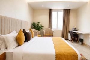a bedroom with a large bed with yellow and white pillows at Hotel Emience in Chandīgarh