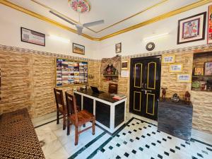 a dining room with a table and chairs and a clock at Hotel Renuka in Jaisalmer