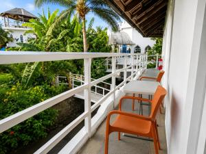 a balcony with tables and chairs and palm trees at MG Chateau Resort in El Nido