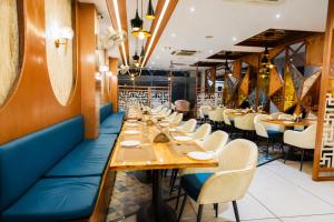 a long dining room with long tables and chairs at Hotel Emience in Chandīgarh