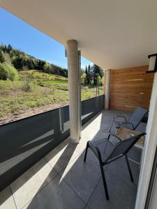 a balcony with two chairs and a large window at FeWo Alissa in Nordrach