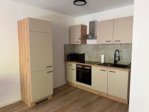a kitchen with white cabinets and a stove top oven at FeWo Alissa in Nordrach