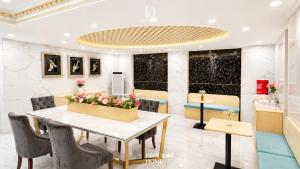 a restaurant with a table with flowers on it at D'Élite Boutique Hotel Dĩ An in Dĩ An