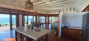 a kitchen with a table and a view of the ocean at Makana 7 in Ponta Mamoli