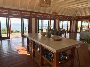 a large room with a table with chairs and the ocean at Makana 7 in Ponta Mamoli +32 photos