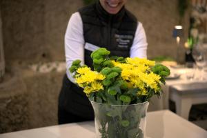a woman is holding a vase of yellow flowers at Casa Valxisto in Penafiel +141 photos