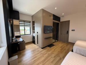 a room with a bedroom with a tv and a bed at Palm Hotel in Tam Kỳ