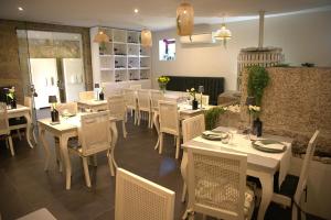 a dining room with white tables and chairs in a restaurant at Casa Valxisto in Penafiel