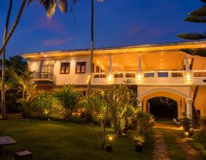 a large building with a courtyard at night at Hotel Indigo in Unawatuna