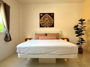 a bedroom with a bed with a picture on the wall at Duplex villa in Khlaung Phai Bae