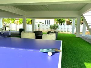 a purple ping pong table with chairs on a lawn at Duplex villa in Khlaung Phai Bae