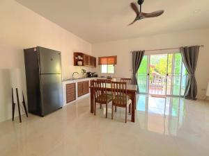 a kitchen with a table and a stainless steel refrigerator at Duplex villa in Khlaung Phai Bae