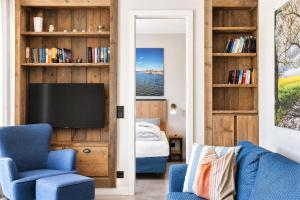 a living room with a blue chair and a tv at Ferienwohnung Heimathafen Villa Martha Binz in Binz