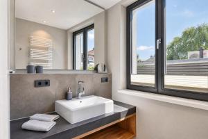 a bathroom with a sink and a large window at Ferienwohnung Heimathafen Villa Martha Binz in Binz +5 photos