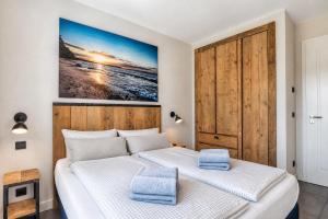 a bedroom with two beds and a painting on the wall at Ferienwohnung Heimathafen Villa Martha Binz in Binz
