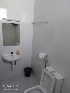 a white bathroom with a toilet and a sink at Chemba's Paradise in Galu +6 photos