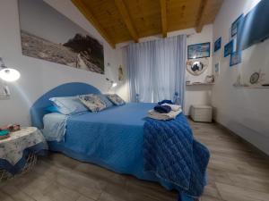 a bedroom with a blue bed with a blue blanket at La Cuppulata 2 - Stile Mare in Enas