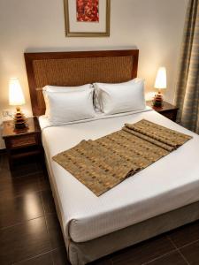 a bed in a hotel room with two nightstands and two lamps at Porto Sharm Elshiekh Vacation Hotel in Sharm El Sheikh +32 photos