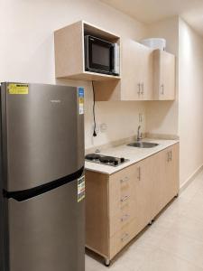 a kitchen with a stainless steel refrigerator and a microwave at Porto Sharm Elshiekh Vacation Hotel in Sharm El Sheikh